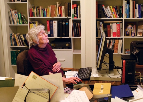 An older woman sits in an office with books. Christine Parker Ammer ’52 has turned her fascination with words into a career as a  lexicographer.