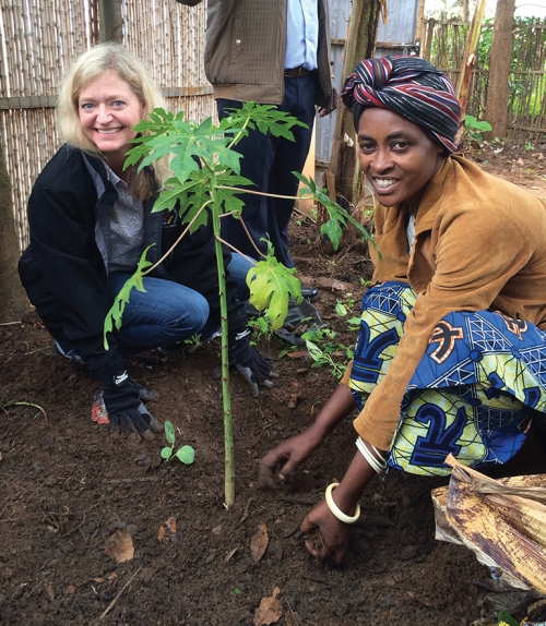 Erica Barks-Ruggles plants a tree with a native woman of Rwanda.