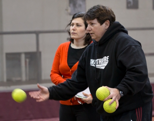 two women throw softballs