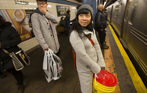 Rebecca Louie waits for a train with her Bokashi bucket