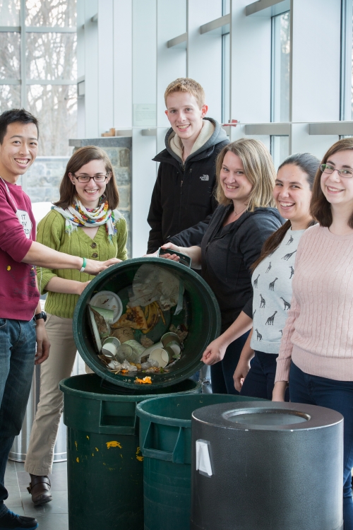 students and staff standing with recycling bins