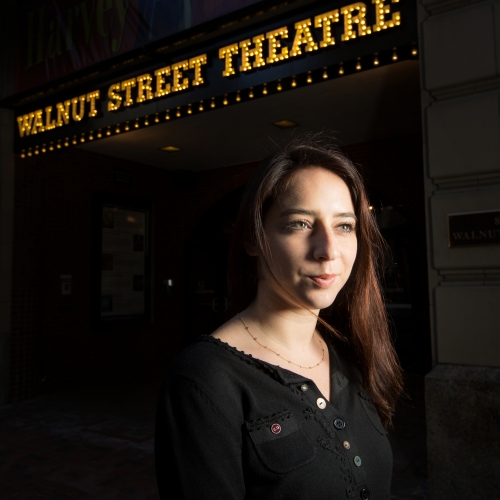 student/professional actress poses in front of a theater
