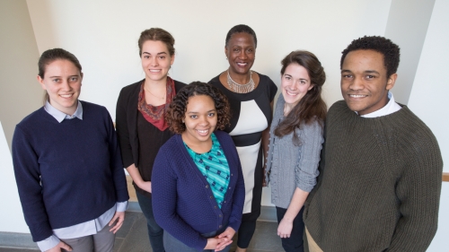 students and a professor smile for the camera