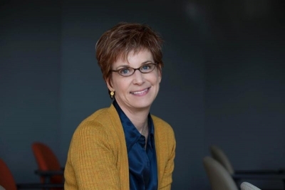 professor in a mustard colored cardigan and glasses