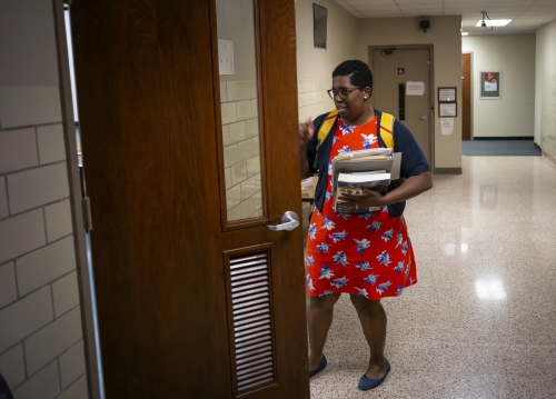 Kimberly St. Julian-Vernon carrying books, entering a classroom