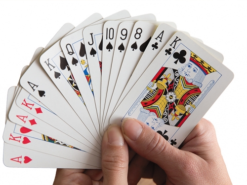 Two hands holds a deck of cards.