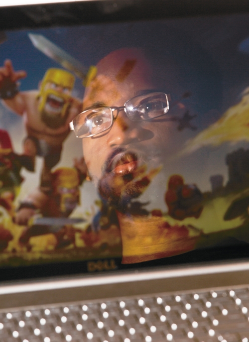 A man is looking at the Clash of Clans combat-oriented game.