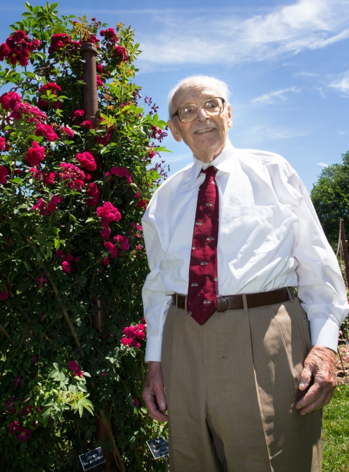 Gene Lang stands front of roses