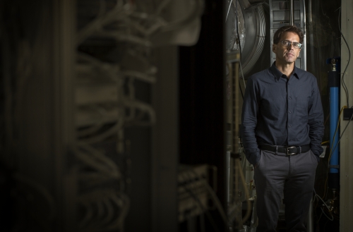 Peter Fritschel ’84 stands beside scientific equipment.