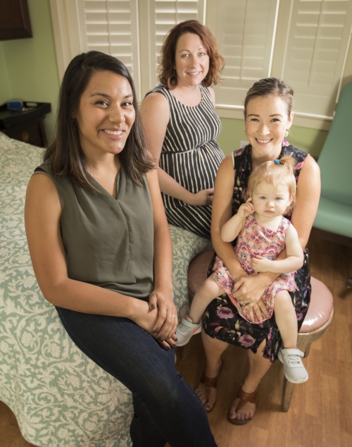 Women and a child sit together in a room. 
