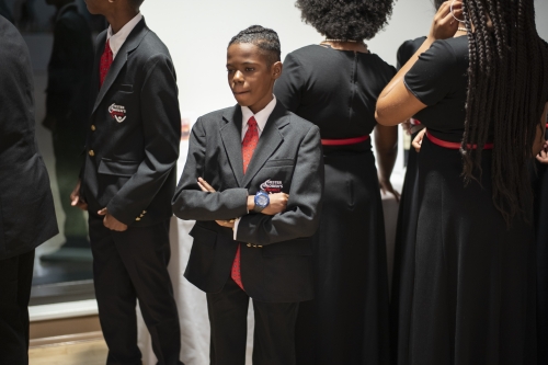boy stands in suit at choir 