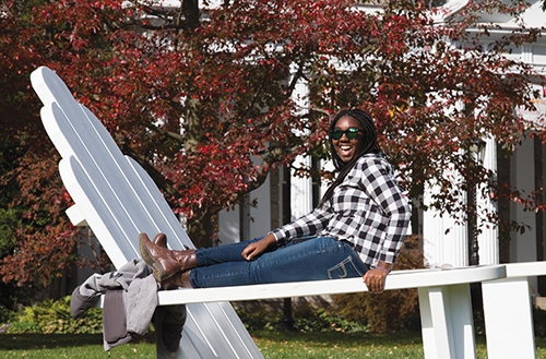 A student poses for a photo on the big chair.