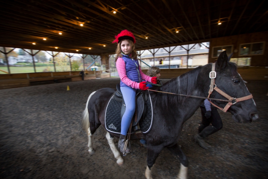 a young girl rides a black horse