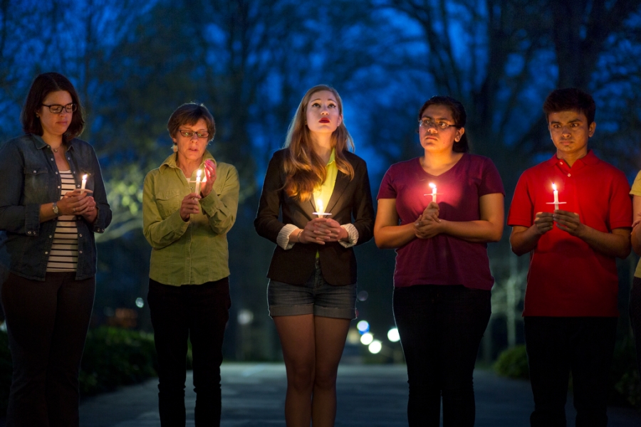 lines of students lit by the candles they hold