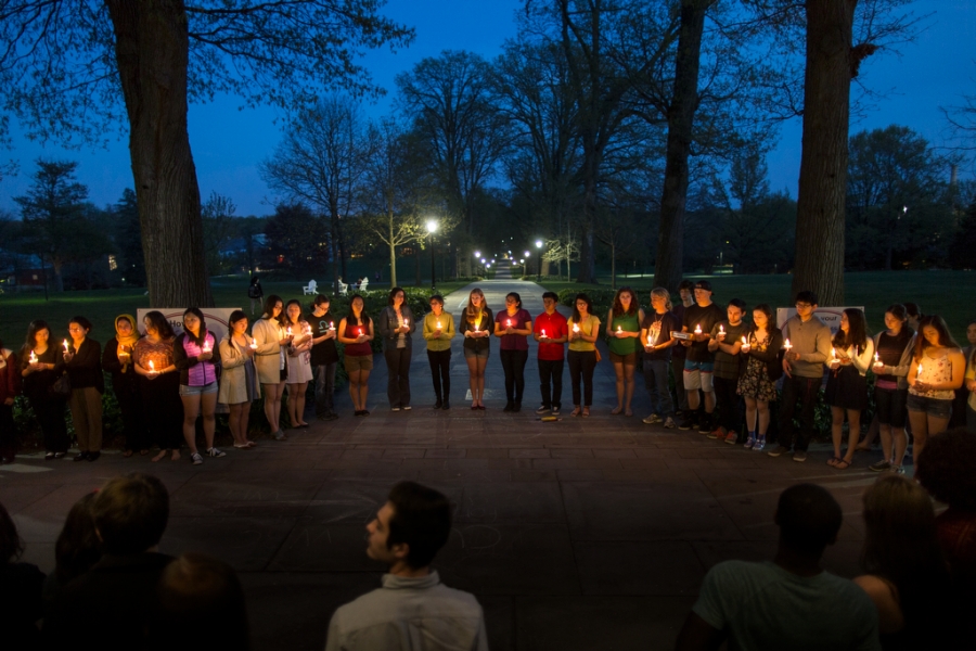a wider shot of the candlelight vigil against the dark blue night sky
