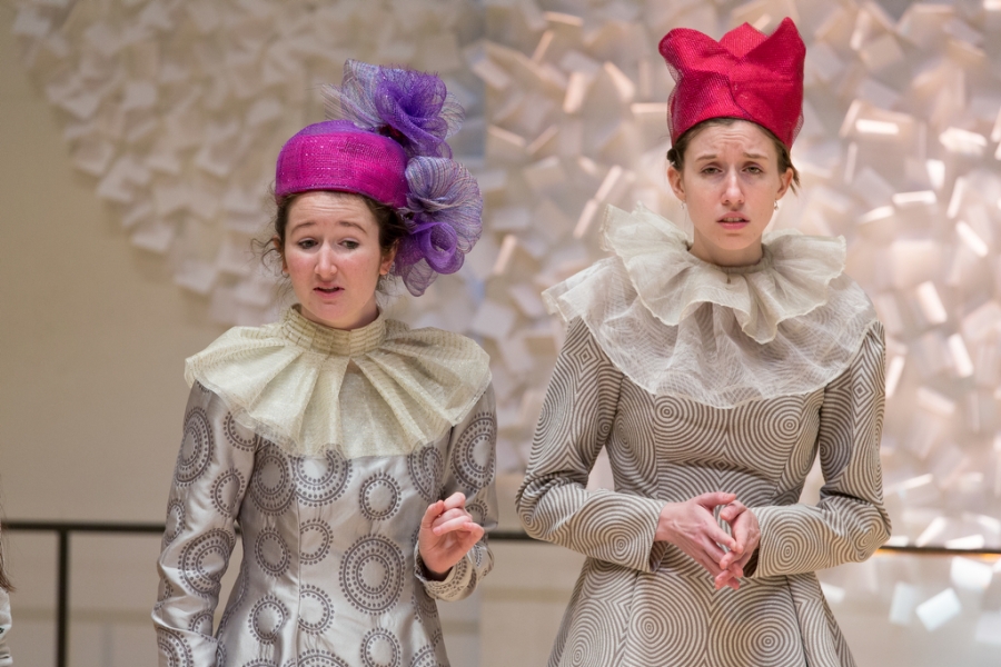 two costumed female students in colorful hats