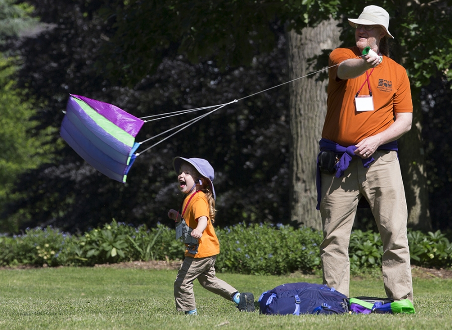 an alum and his son play with a kite on campus