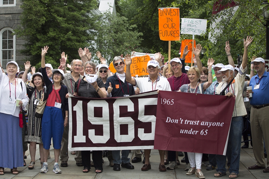 members of the class of 1965 carry a banner celebrating their class