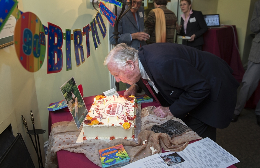 A man blows out candles on a birthday cake. 