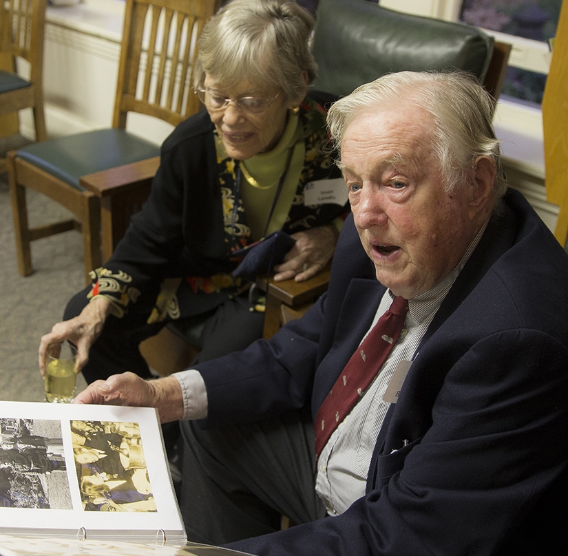 A man and a woman look at a book. 