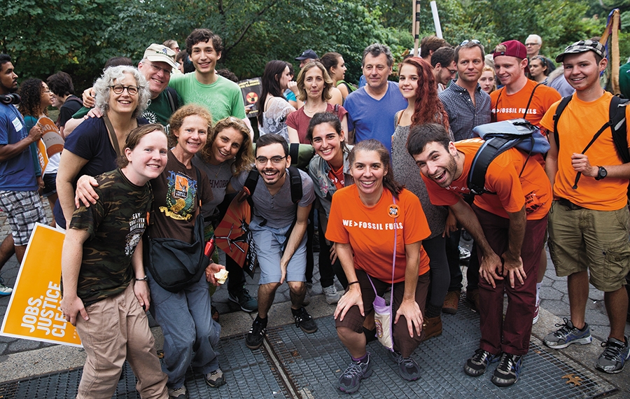 A group of smiling people take part in the People's Climate March in New York City.