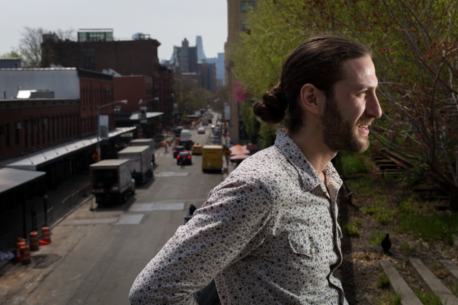 Profile of a man with a pony tail in the street. 