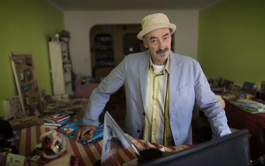 Barry Yourgrau ’70 stands in a green-walled apartment