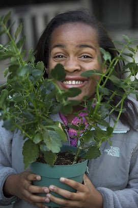 a student holds a beautiful houseplant