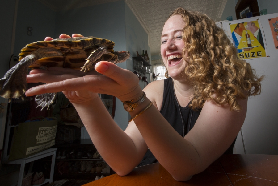 woman holds turtle both appear content