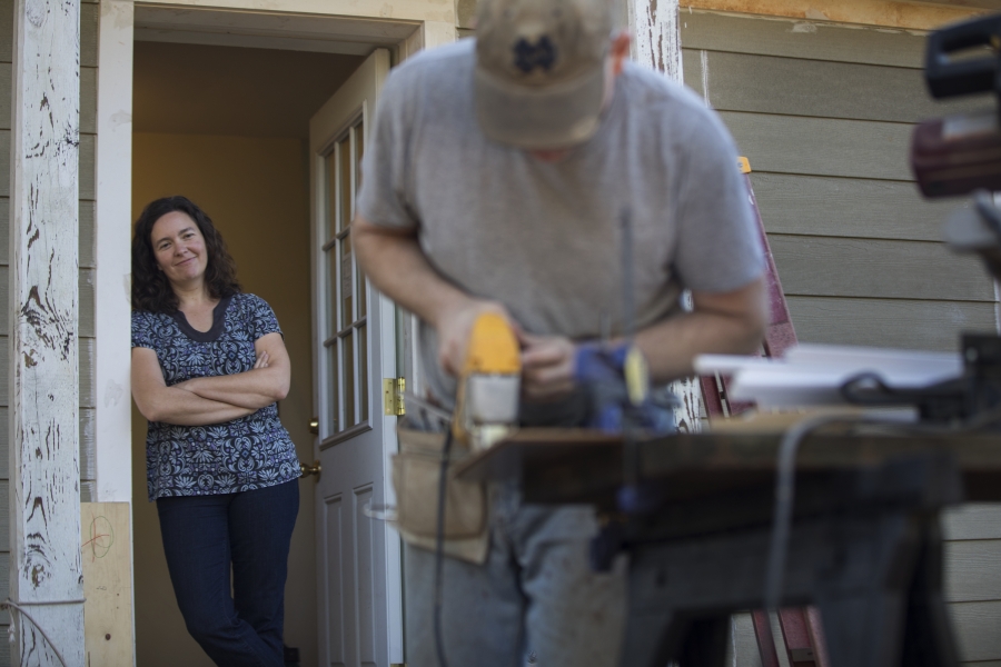 Laura Snyder Brown watching her husband cut wood planks.