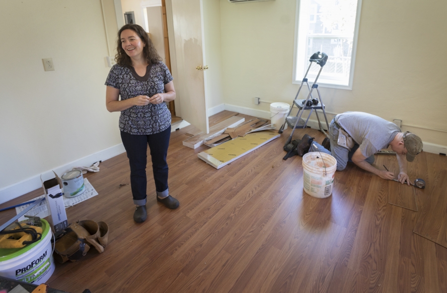Laura Snyder Brown watching her husband lay wood flooring.