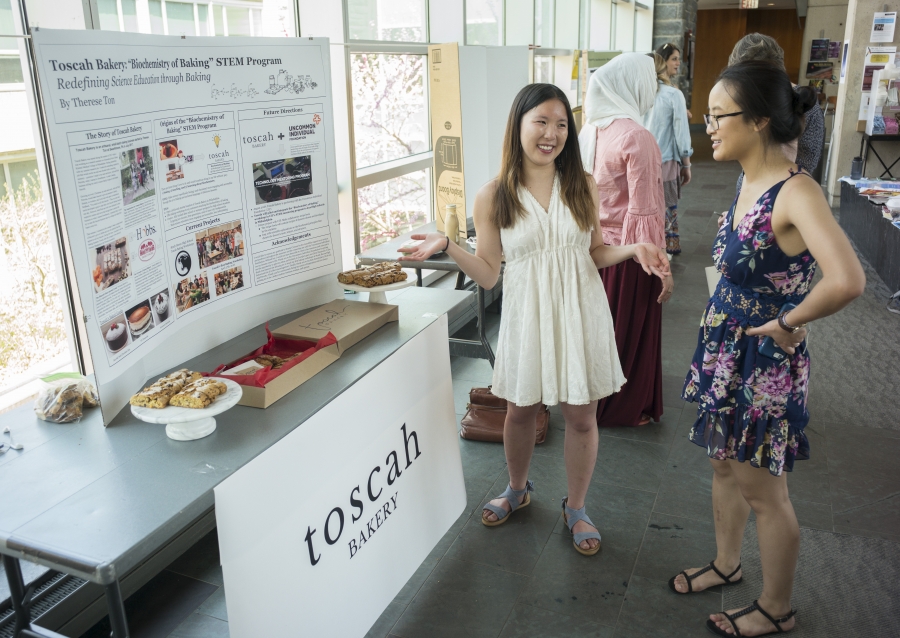 Therese Ton next to a booth display about Toscah Bakery