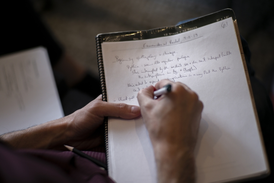 Person writes in Greek in book