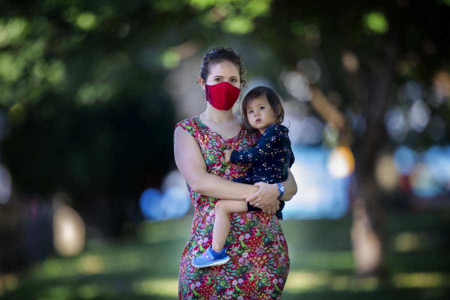 Marina Isakowitz '09 in a mask, holding her daughter