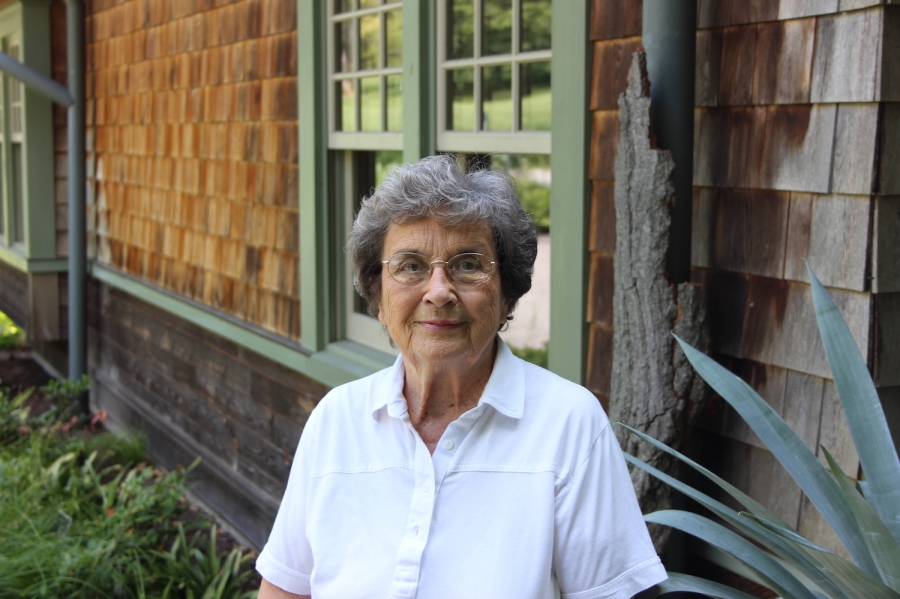 a woman stands in front of the arboretum office