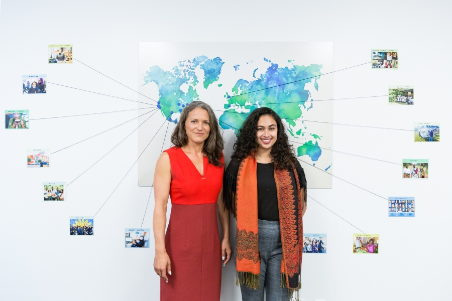 Morgan Simon ’04 and Jasmine Rashid ’18 standing in front of a world map