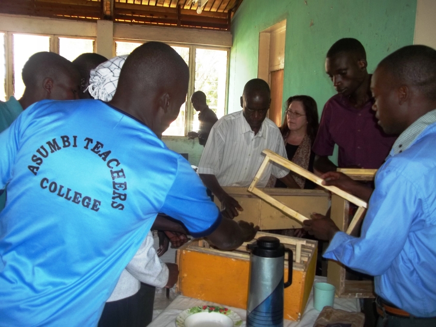 A group of men and a woman building bee woodenware.