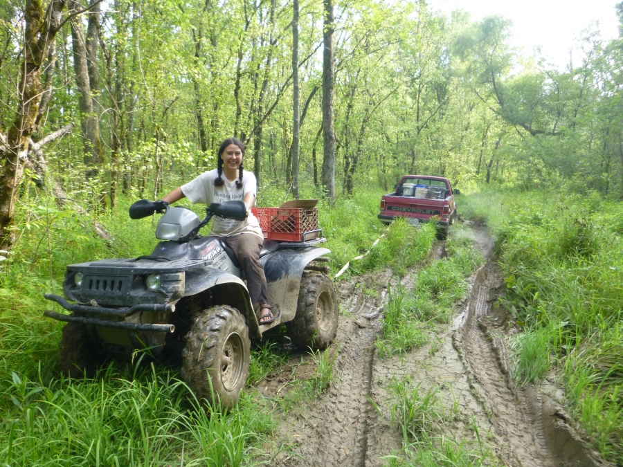 Anna Hess ’00 driving a four-wheeler stuck in the mud
