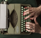 Hands typing on a green typewriter