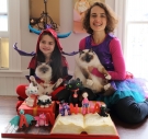 Polina Kehayova ’01, her daughter Anna, and their cats pose with an elaborate cake Polina created.