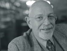 black and white photo of a man in a jacket looking at the camera