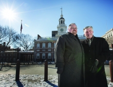 two men stand in Philadelphia in winter coats