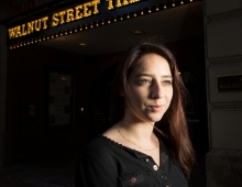 student/professional actress poses in front of a theater