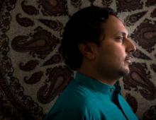 Amer Ahmed in profile, wearing a turquoise shirt