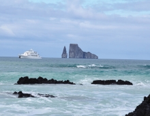 Cliffs, boat in the distance on ocean. 