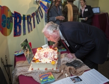 A man blows out candles on a birthday cake. 