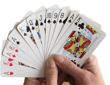 Two hands holds a deck of cards.