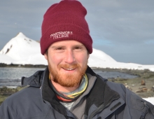 Wiley Archibald ’10 holds a days-old Antarctic fur seal pup with a still-attached umbilical cord.