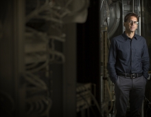 Peter Fritschel ’84 stands beside scientific equipment.