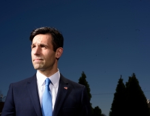 Joe Khan in a suit against a blue sky